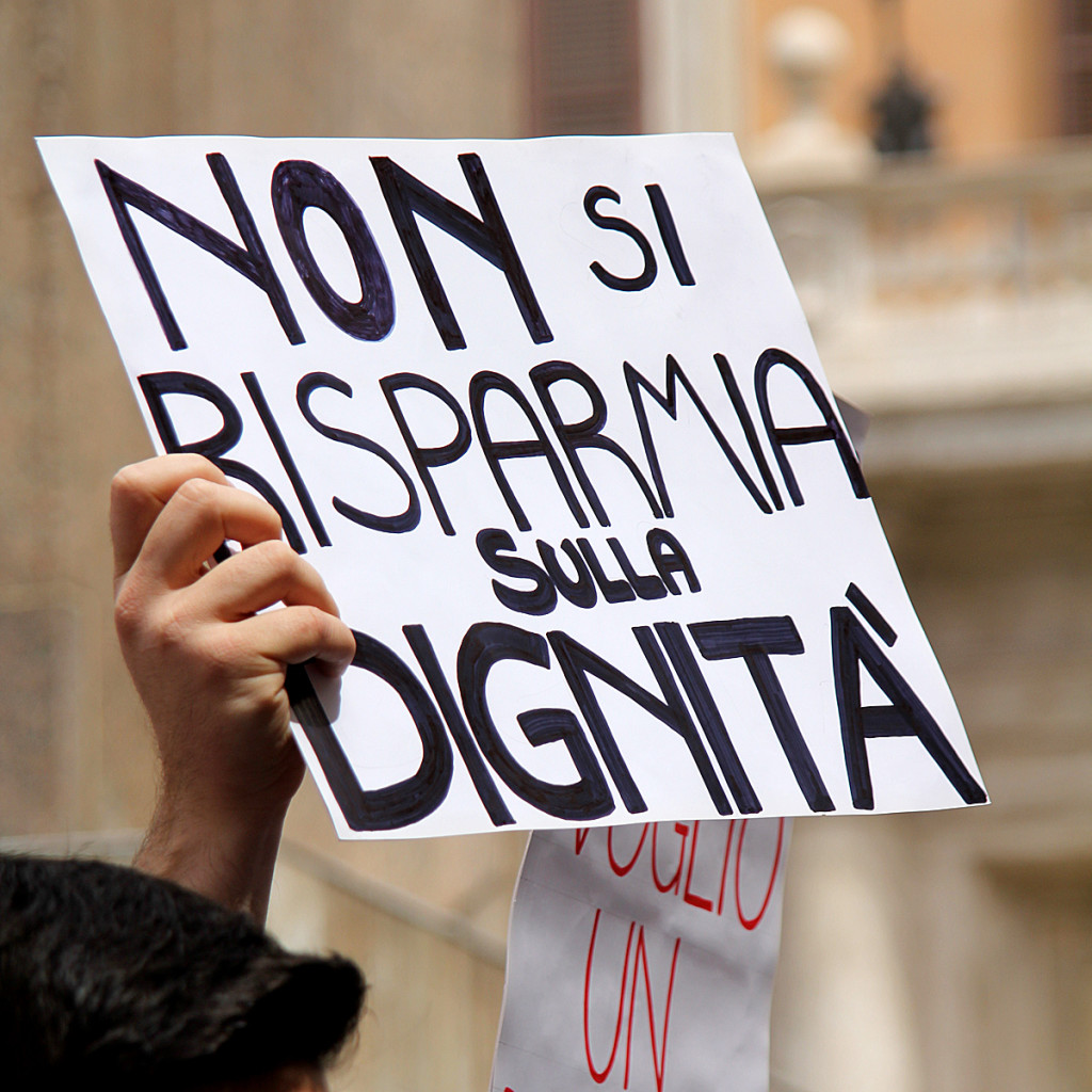 Manifesto "Non si risparmia sulla dignità" esibito durante la protesta a piazza Montecitorio