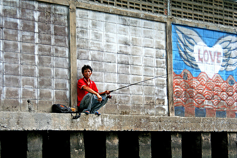 Pescatore lungo un canale di Bangkok